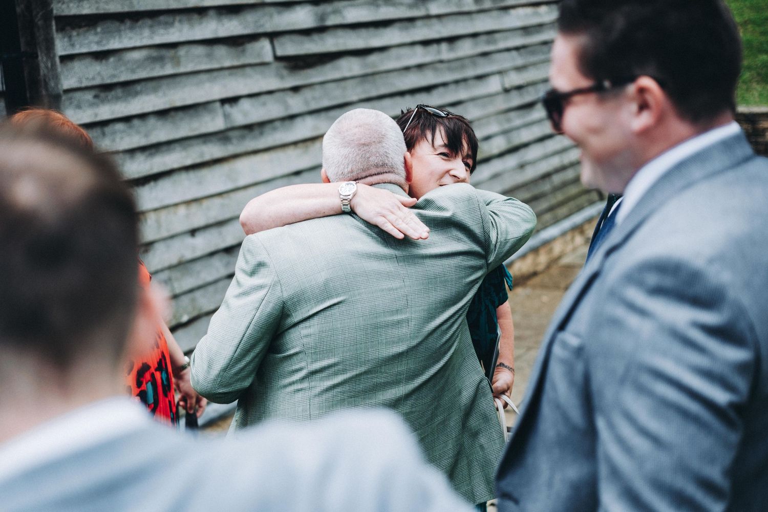 Emotional moment shared between guests during an outdoor wedding celebration.