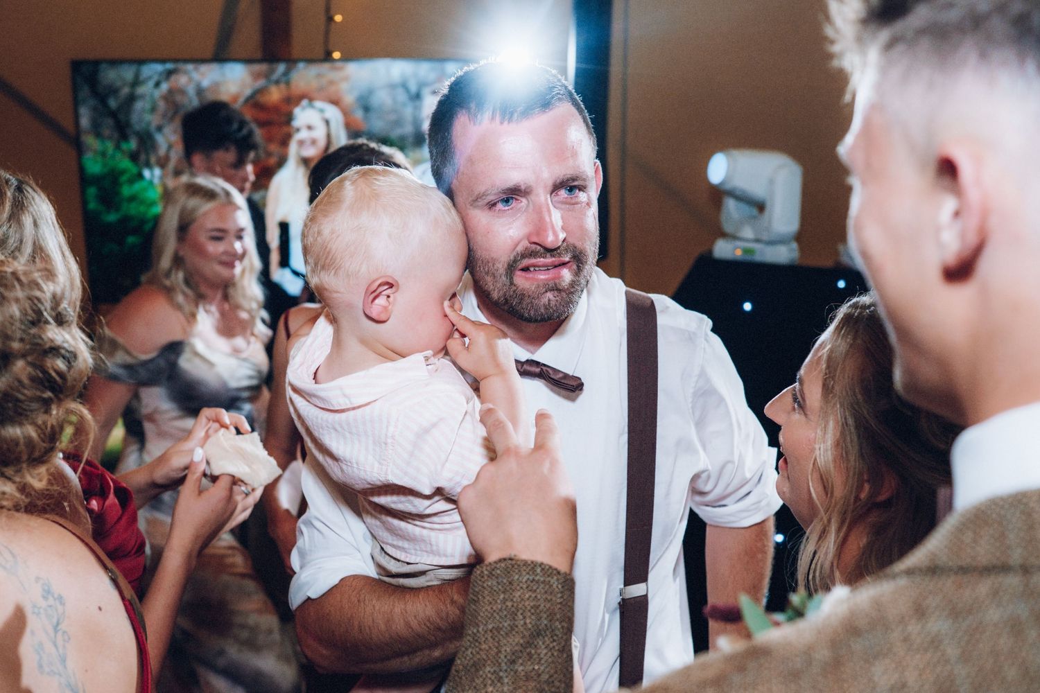 Candid moments of celebration captured under string lights at evening reception.