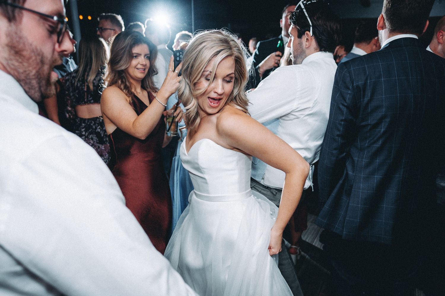 Energetic dance party scene with guests in formal attire enjoying the celebration.
