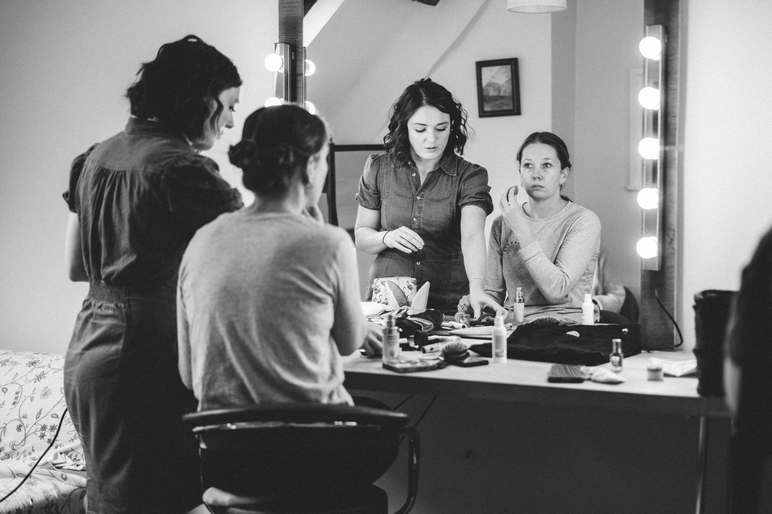 Black and white image of a dressing room scene with mirrors and makeup tables.