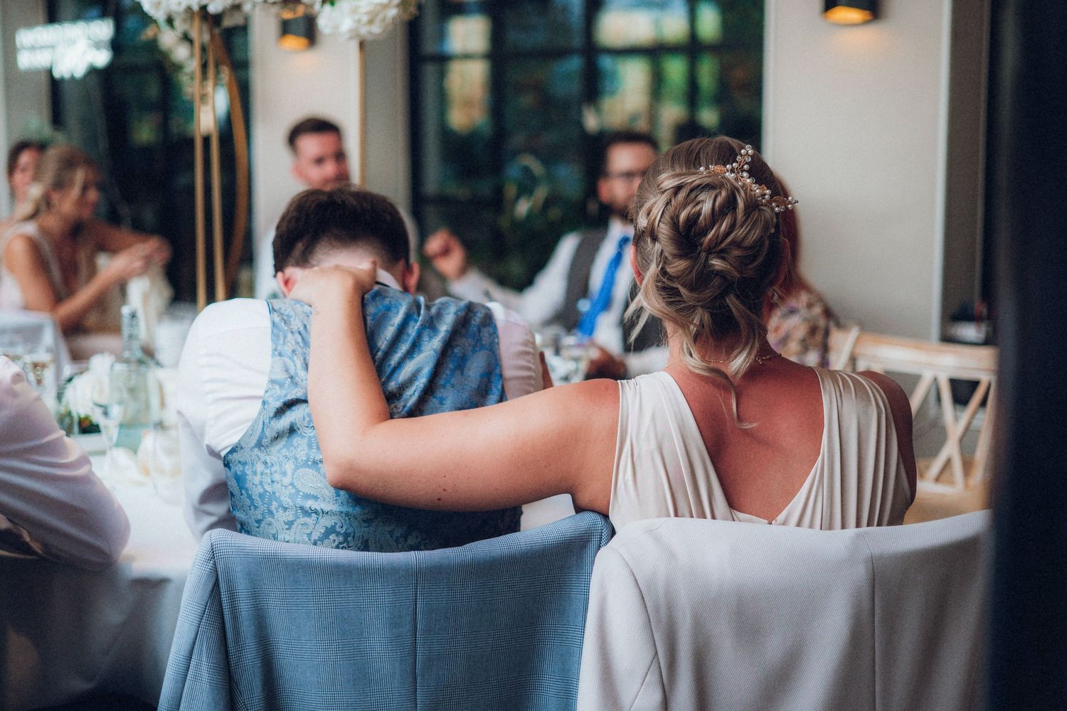 Guests chatting intimately at round tables during an indoor wedding reception.