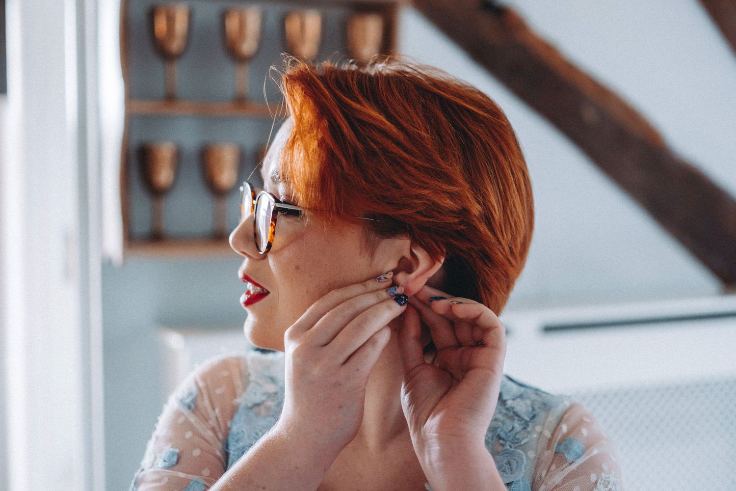 Getting ready moments captured in natural window light with vintage decor.