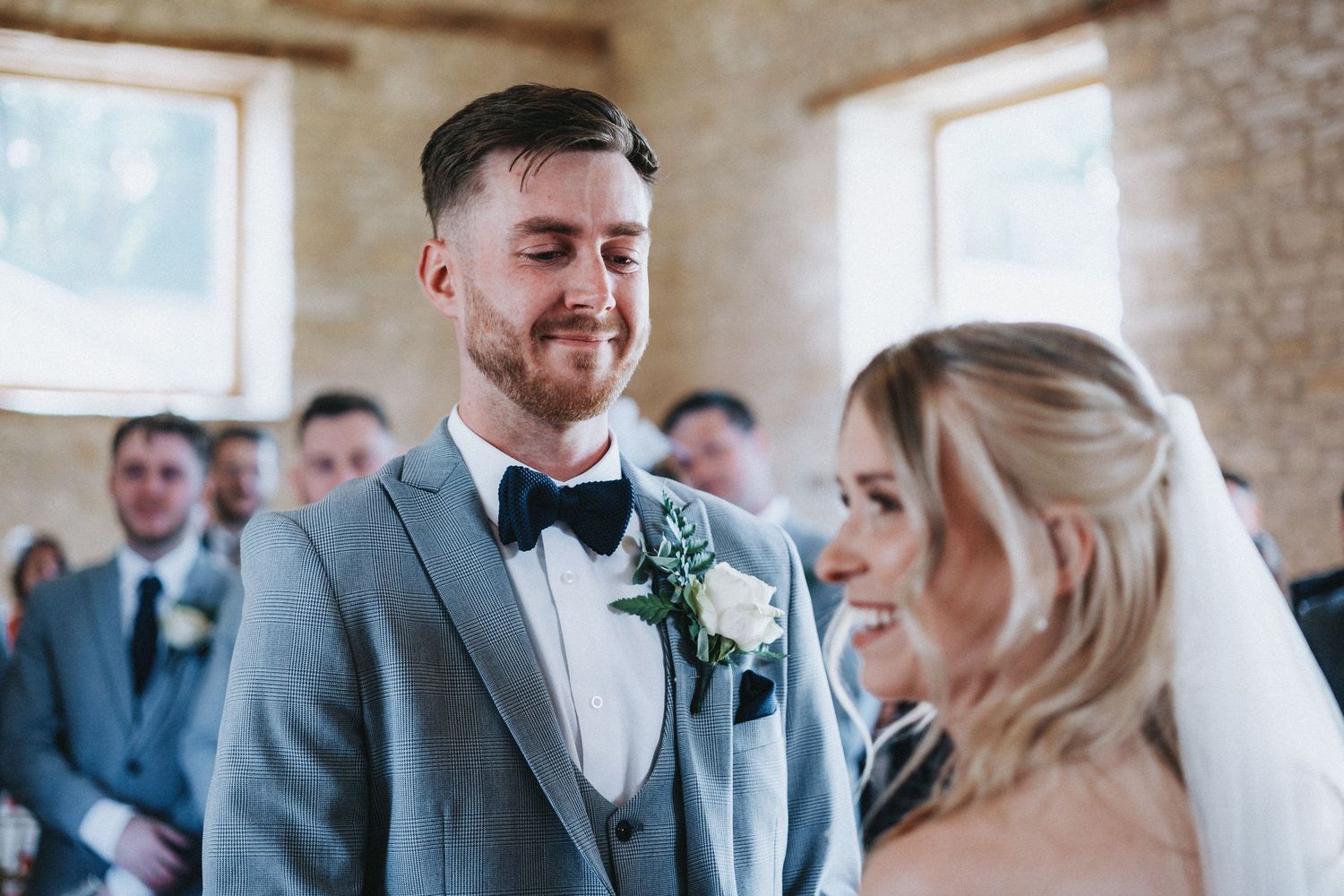 Wedding guests share smiles and laughter during an indoor celebration.