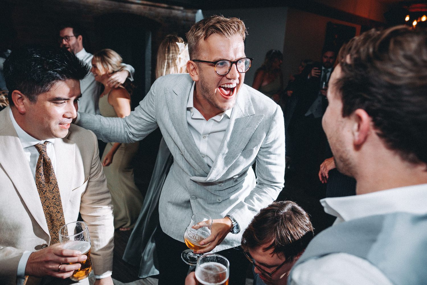 Candid moments of celebration captured at a wedding reception dance party.