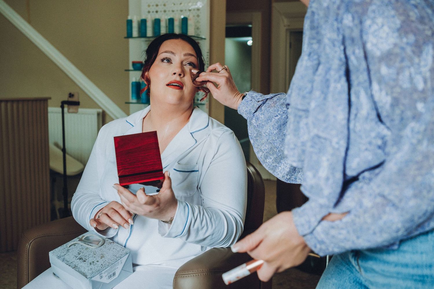Getting ready moments captured in a room with turquoise decor details.