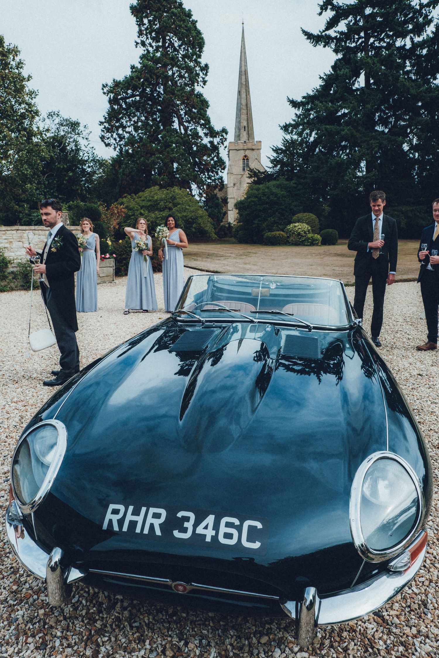 Classic Jaguar E-Type sports car with registration RHR 346C parked at wedding venue.