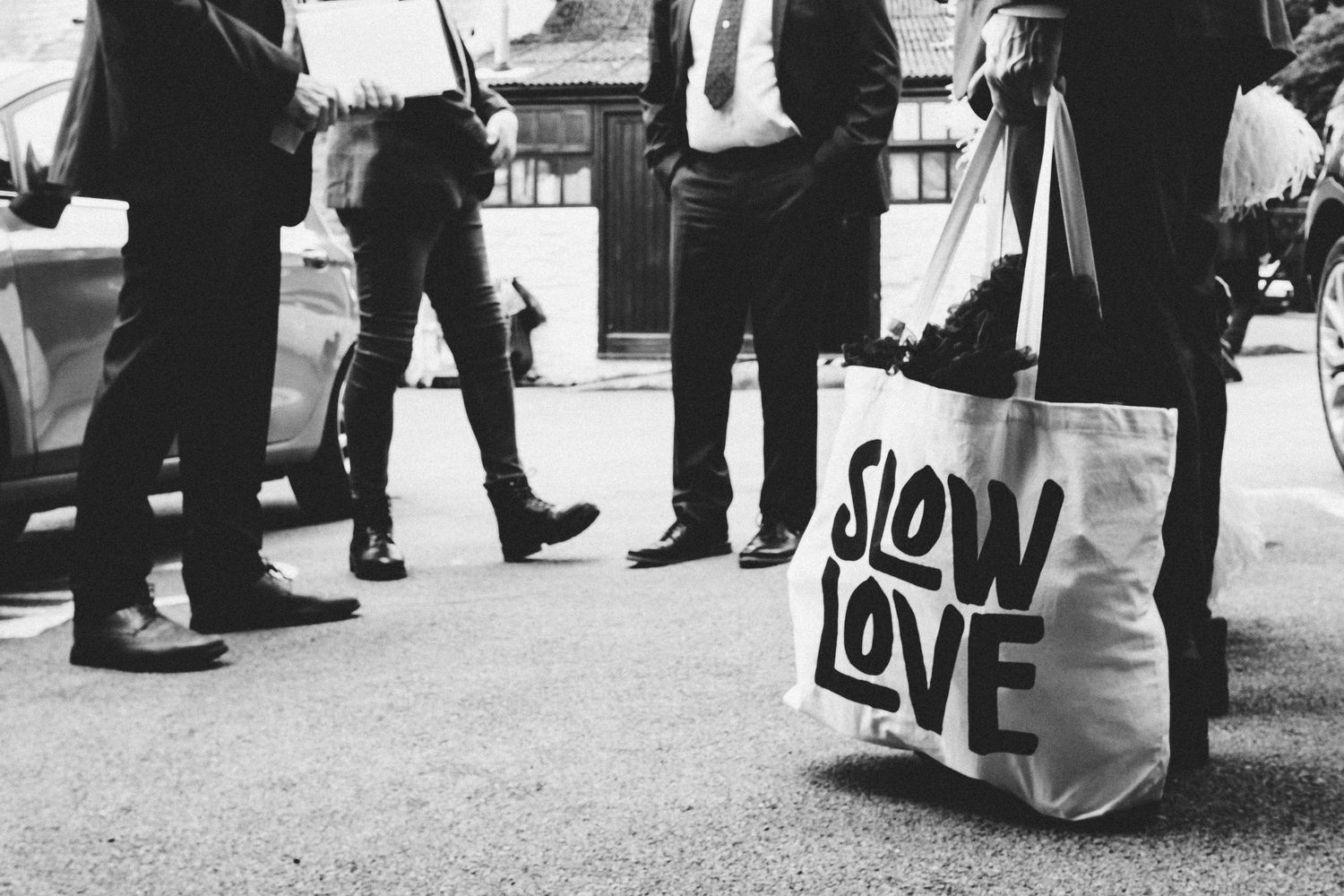Wedding guests mingling at an outdoor reception with a 'LOVE' sign visible.