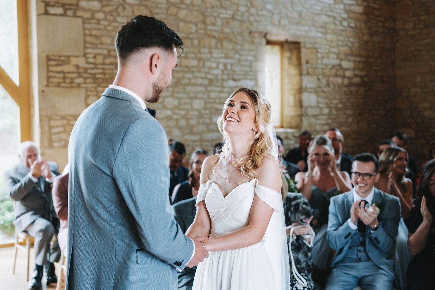 Wedding ceremony in rustic stone barn venue with natural lighting.