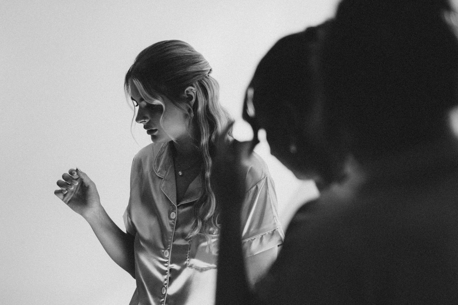 Black and white photo of emotional wedding preparations in morning light.