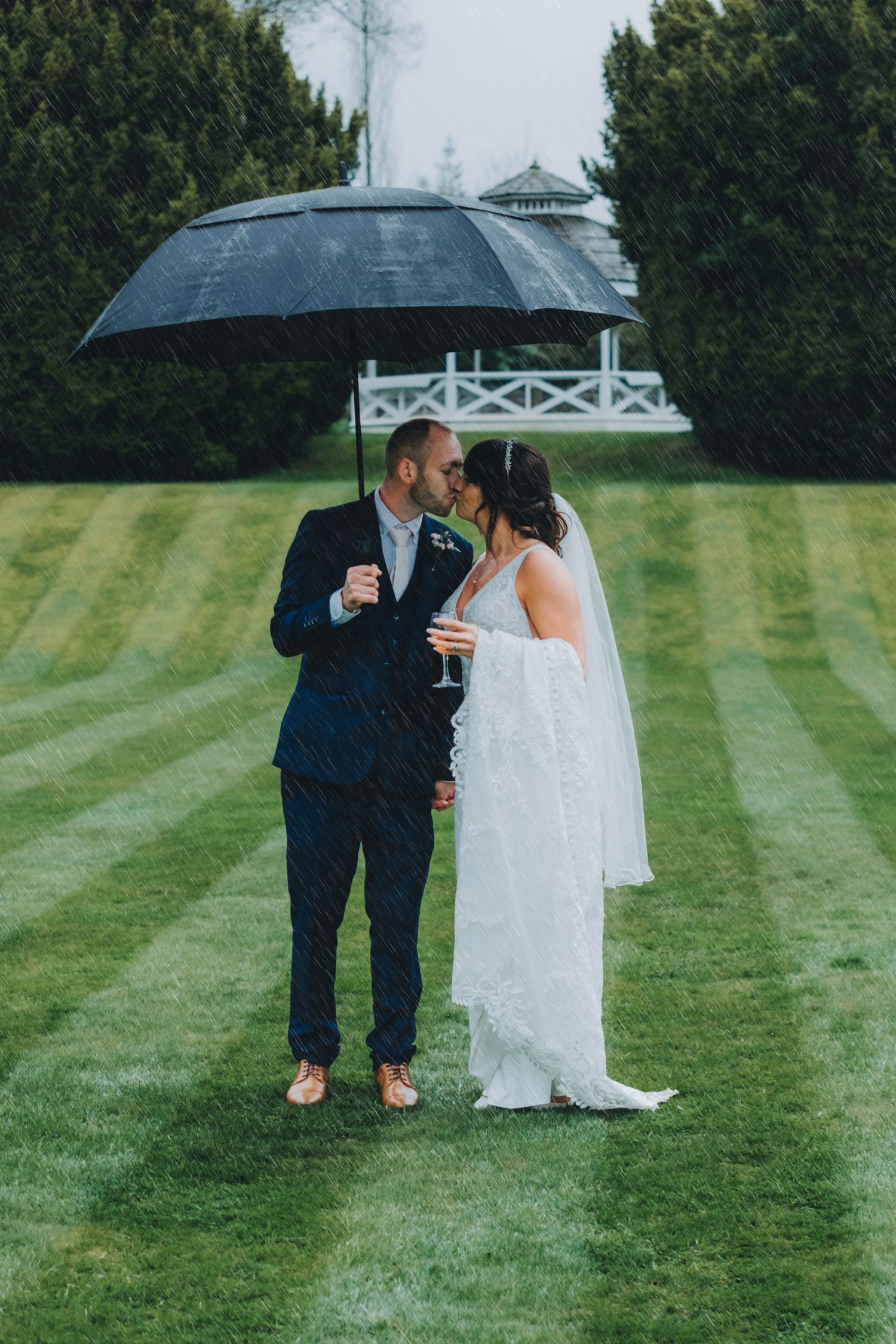 Newlyweds share intimate dancing moment during wedding reception in dimly lit venue.