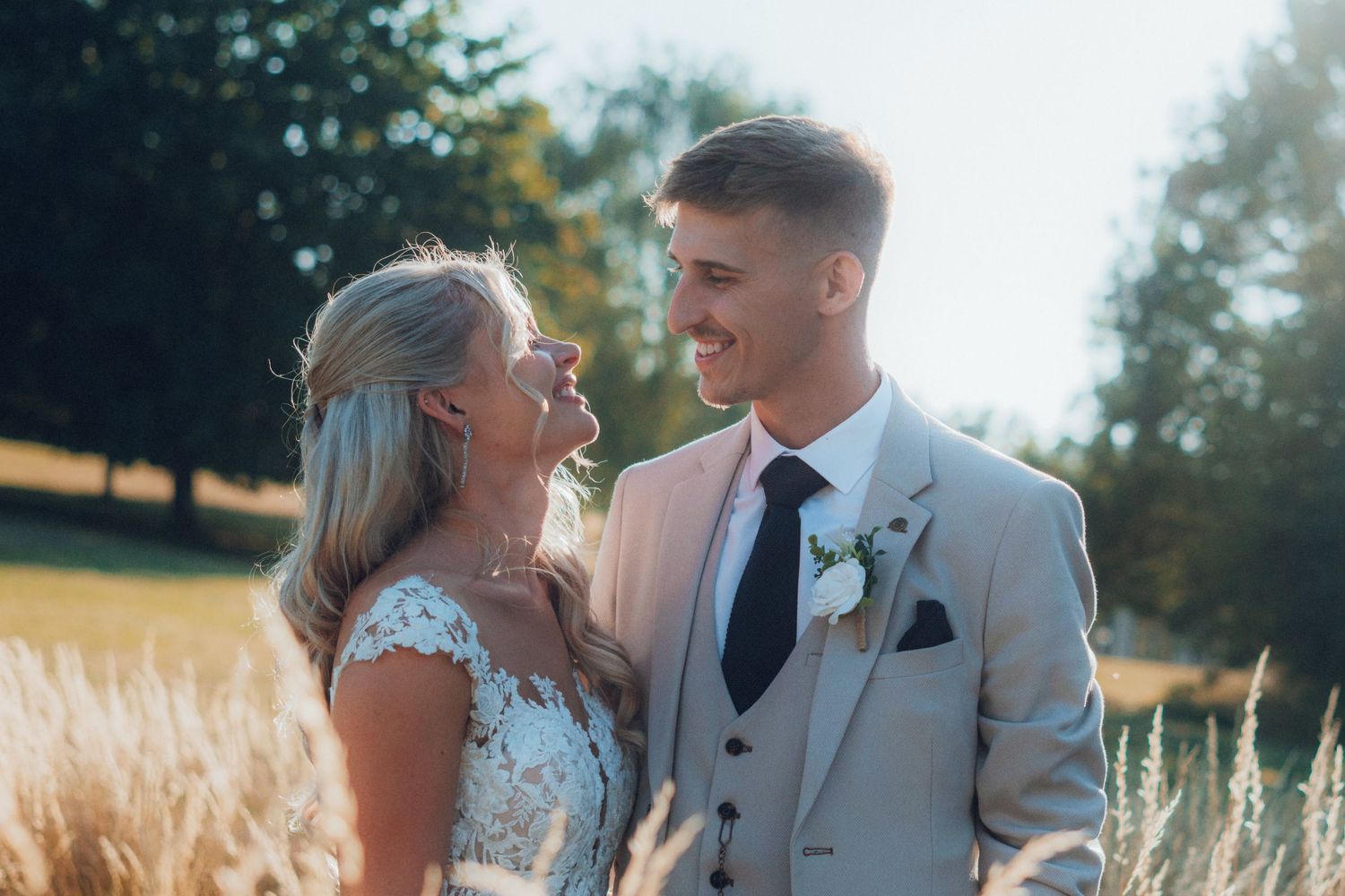 Newlyweds share an intimate moment in a sunlit garden setting.