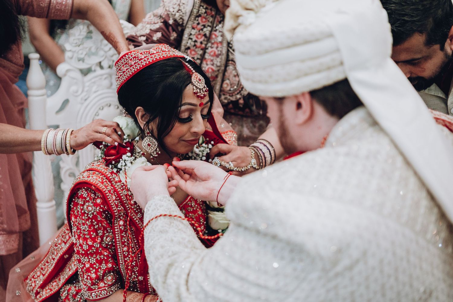 Traditional wedding ceremony with exchange of garlands and red bridal attire.