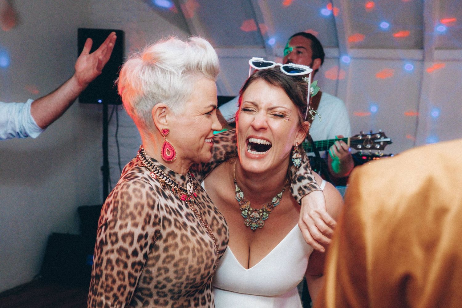 Festive dance floor scene with disco lights creating blue and red patterns across the celebration.