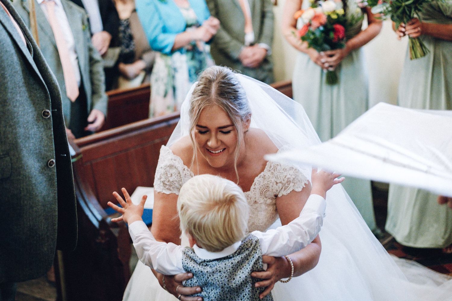 Wedding party members share joyful moments during an outdoor celebration.