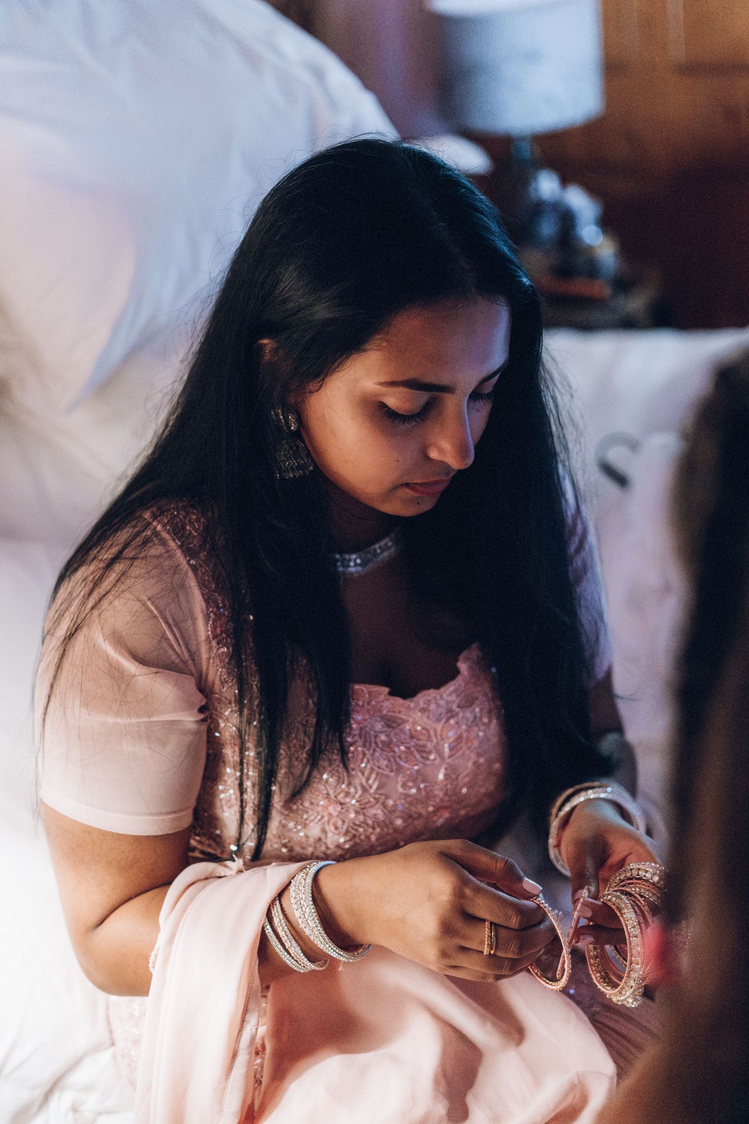 Person in white dress seated during a formal event preparation.