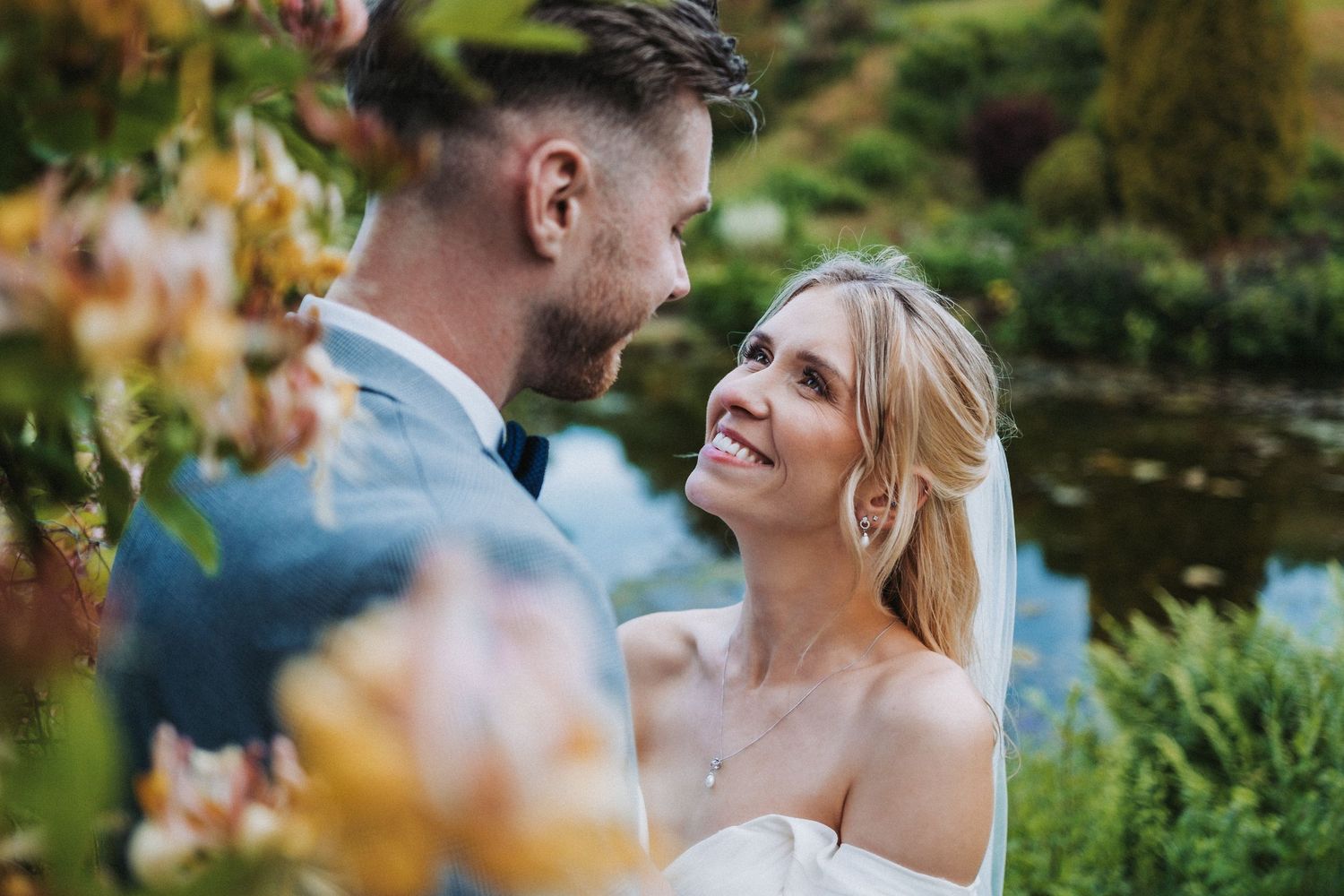 A happy couple shares an intimate moment outdoors in a romantic garden setting during their fall wedding.