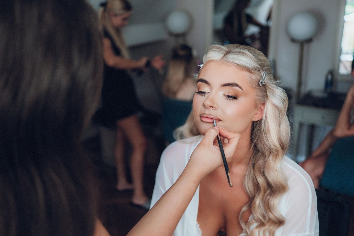 Wedding morning preparations with elegant makeup and styling in progress.
