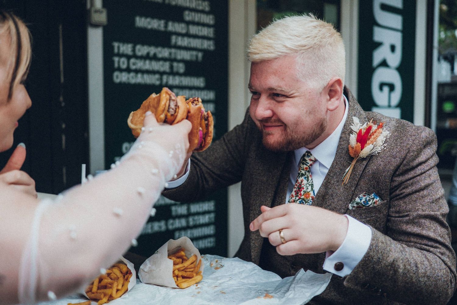 Wedding guests enjoy food and drinks at an indoor reception venue.