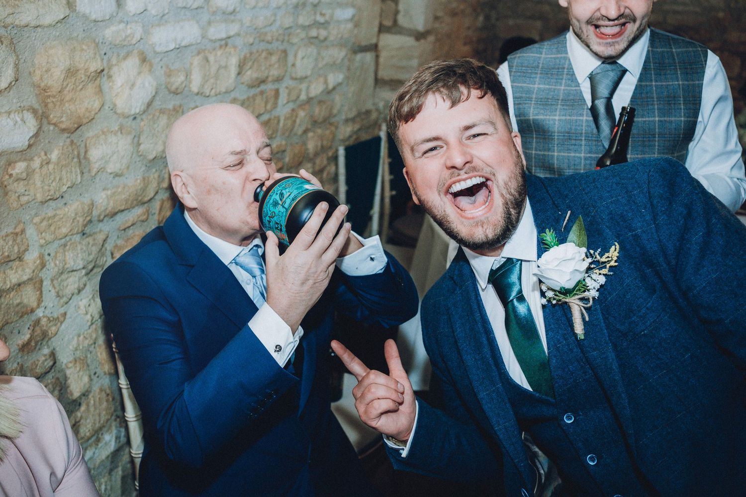 Wedding guests share laughs and drinks during reception celebration.