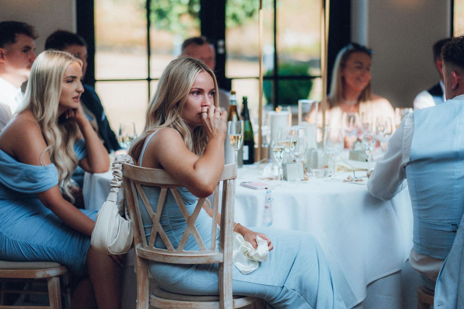 Wedding guests enjoying dinner and conversation at elegantly decorated tables.