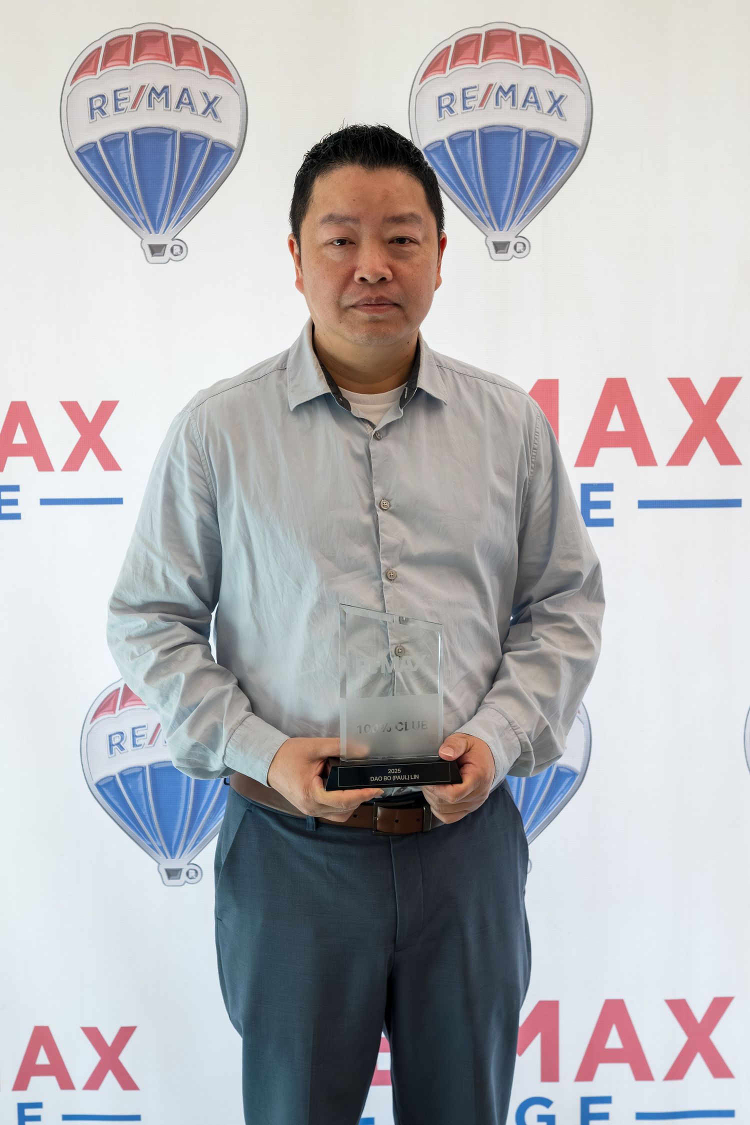 RE/MAX Edge agent holds achievement award at RE/MAX Edge recognition ceremony.