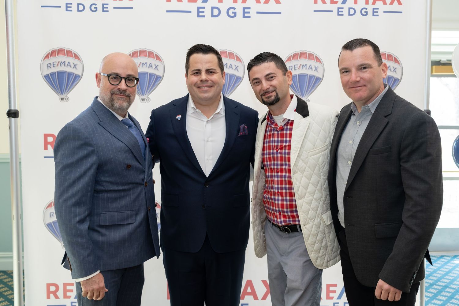 Four men smile together at RE/MAX Edge annual awards ceremony.