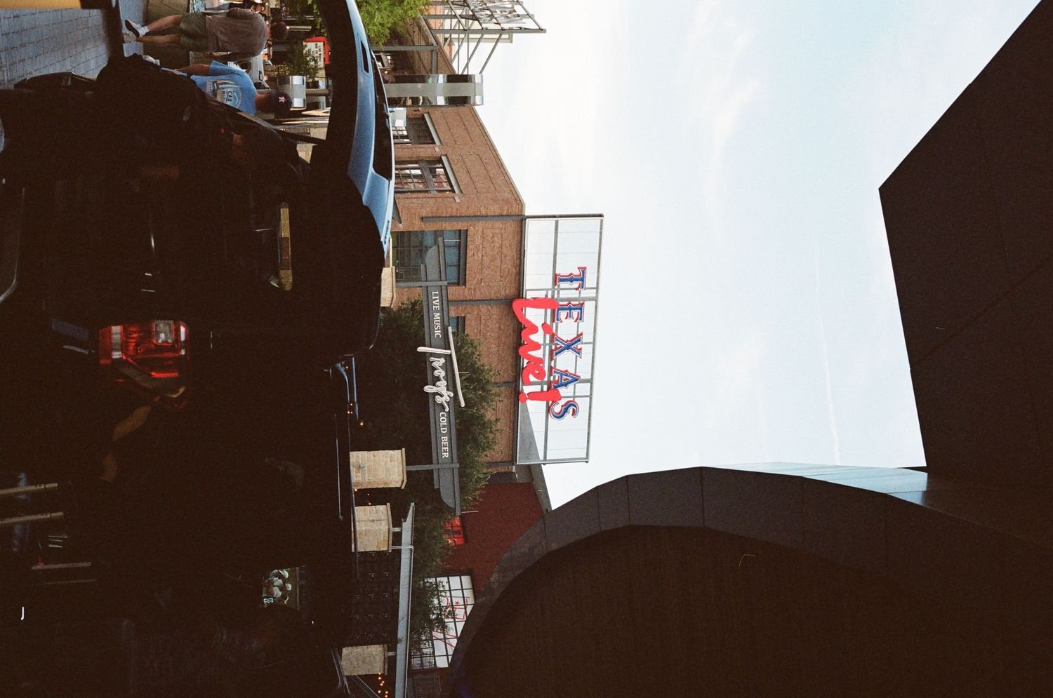 Street level view of Texas de Brazil restaurant sign on brick building in city.