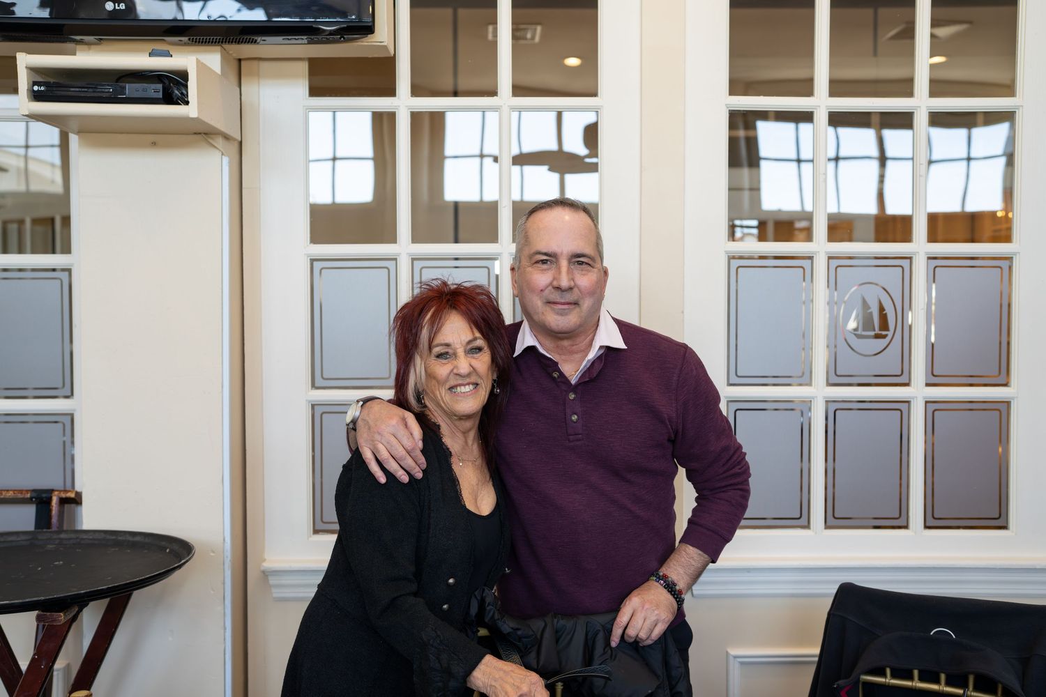A smiling couple posing together at a RE/MAX Edge real estate office event.