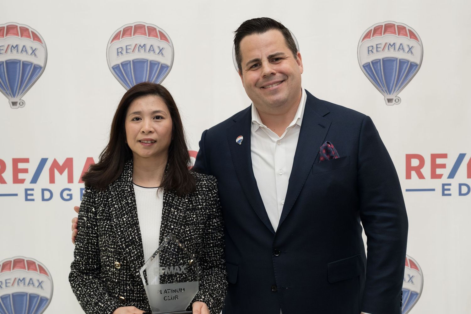 Female RE/MAX Edge agent poses with broker at RE/MAX Edge awards event.