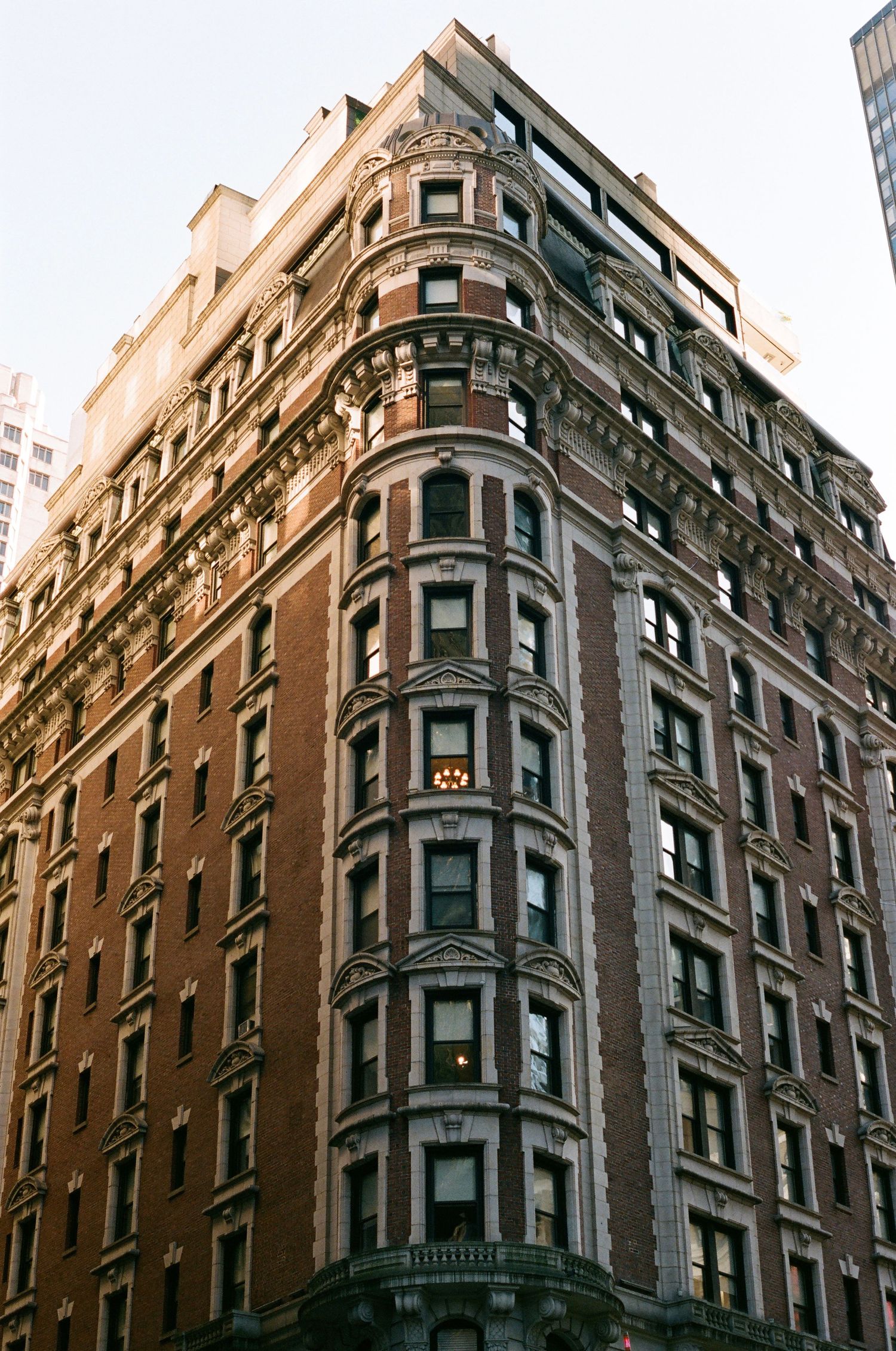 Ornate historic flatiron-style brick building with decorative facades on a New York City corner.