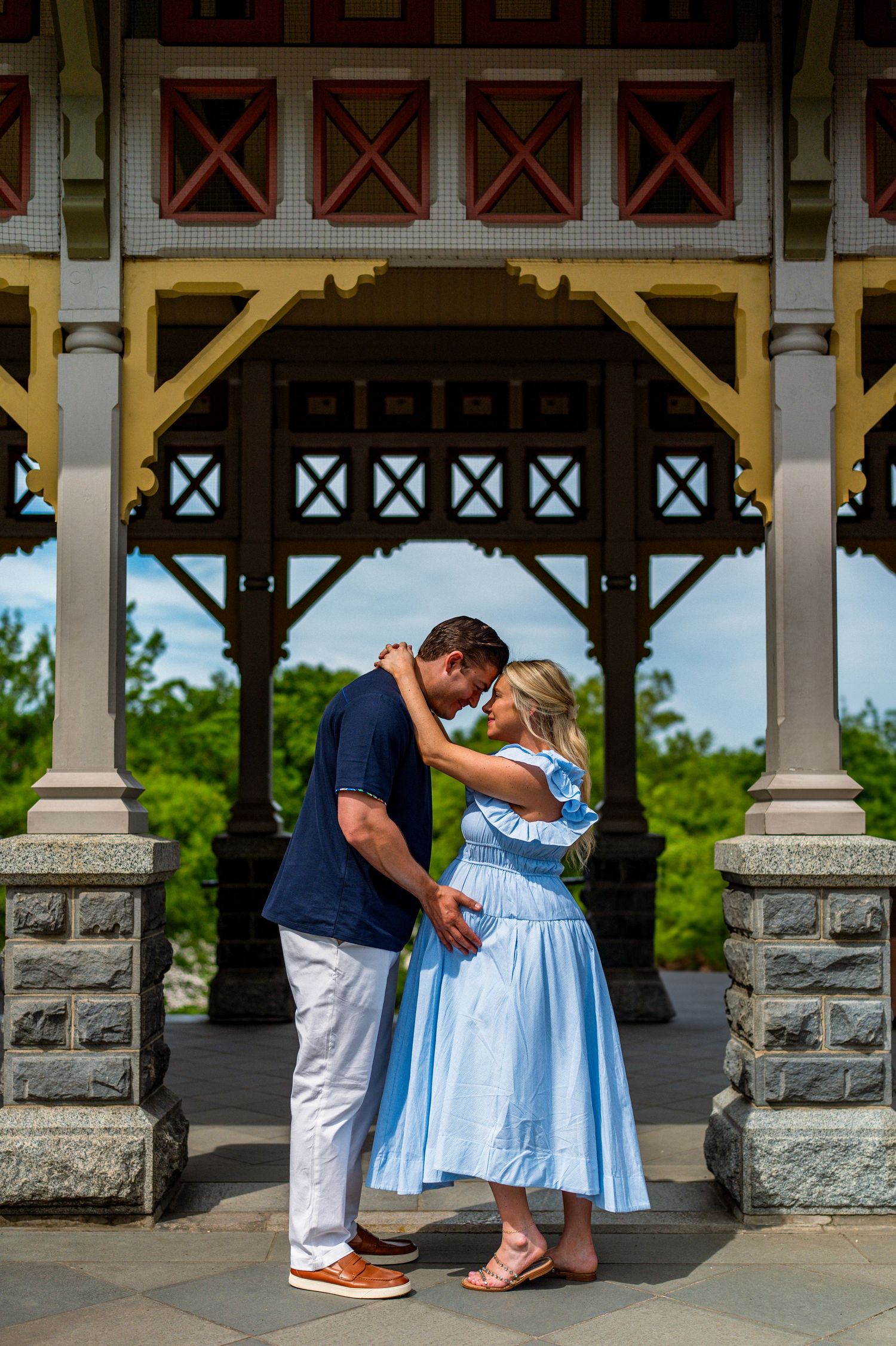 Couple sharing a romantic moment under a colorful gazebo in Central Park, New York.