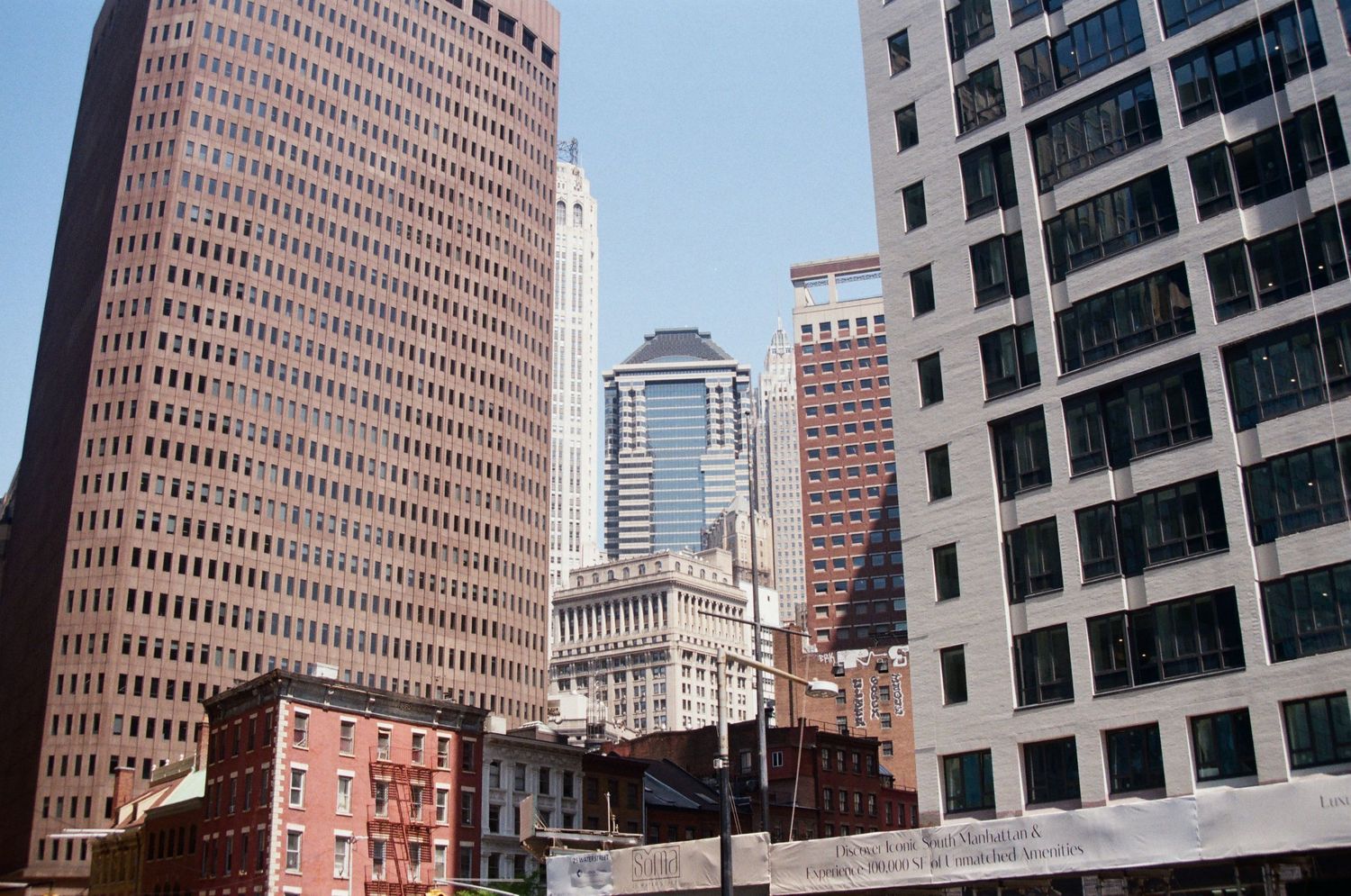 Urban cityscape featuring tall modern glass and brick skyscrapers in a busy downtown financial district.