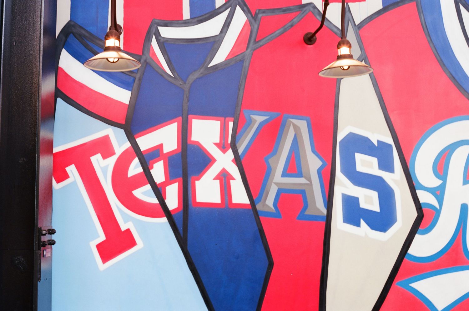 Colorful Texas Rangers baseball mural featuring red and blue jerseys with bold lettering on a restaurant wall.