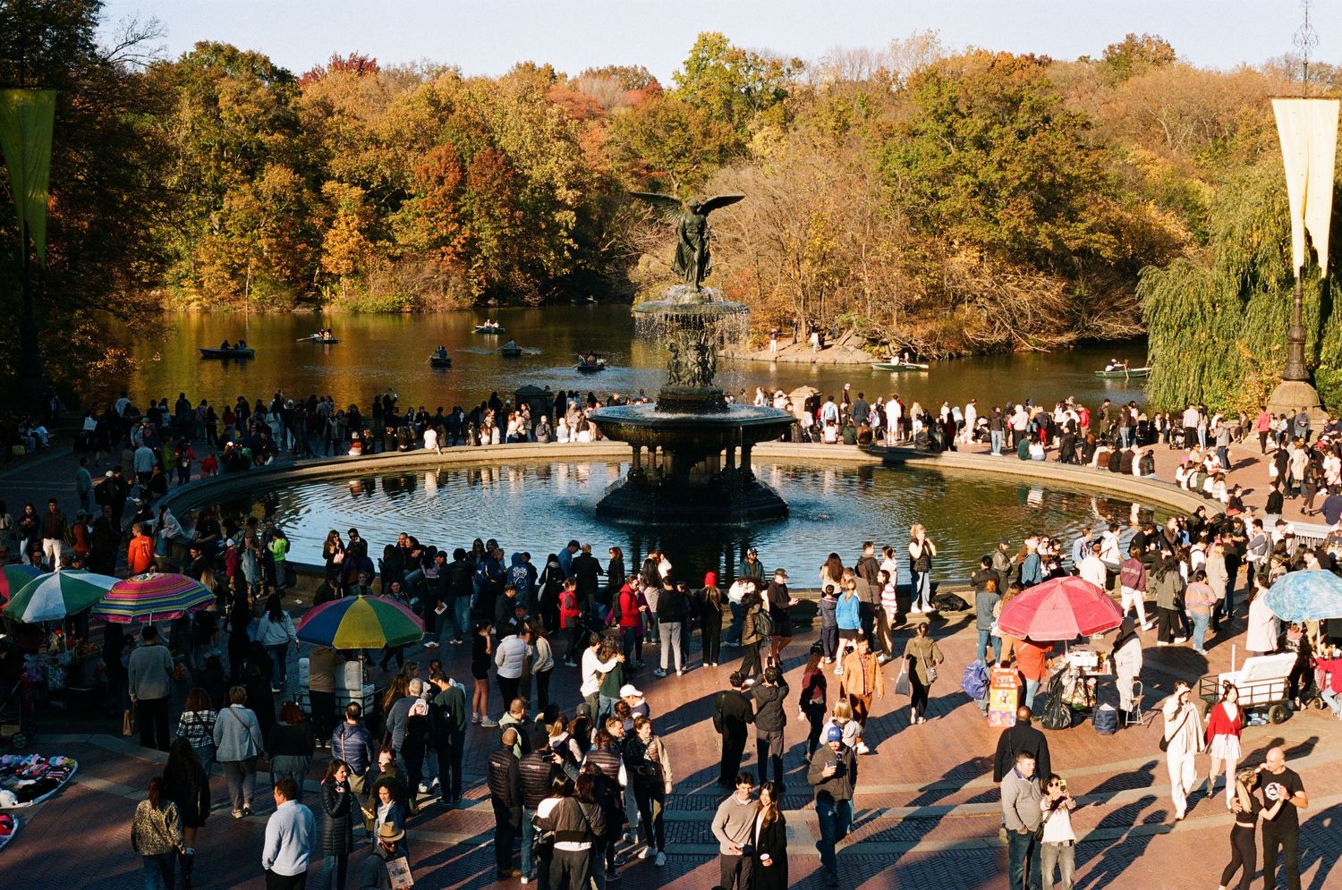 Aerial view of crowd gathered around Bethesda Fountain in Central Park during autumn.