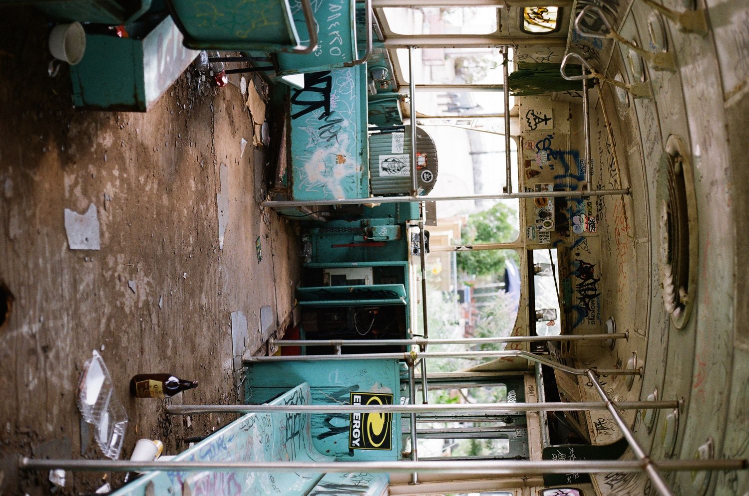 Abandoned industrial machinery and equipment in a run-down warehouse with turquoise painted walls.