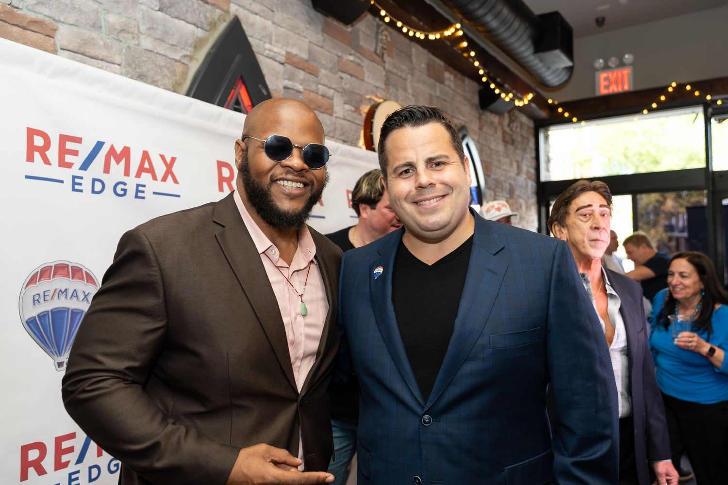 Two men smile together at a RE/MAX Edge real estate networking event.