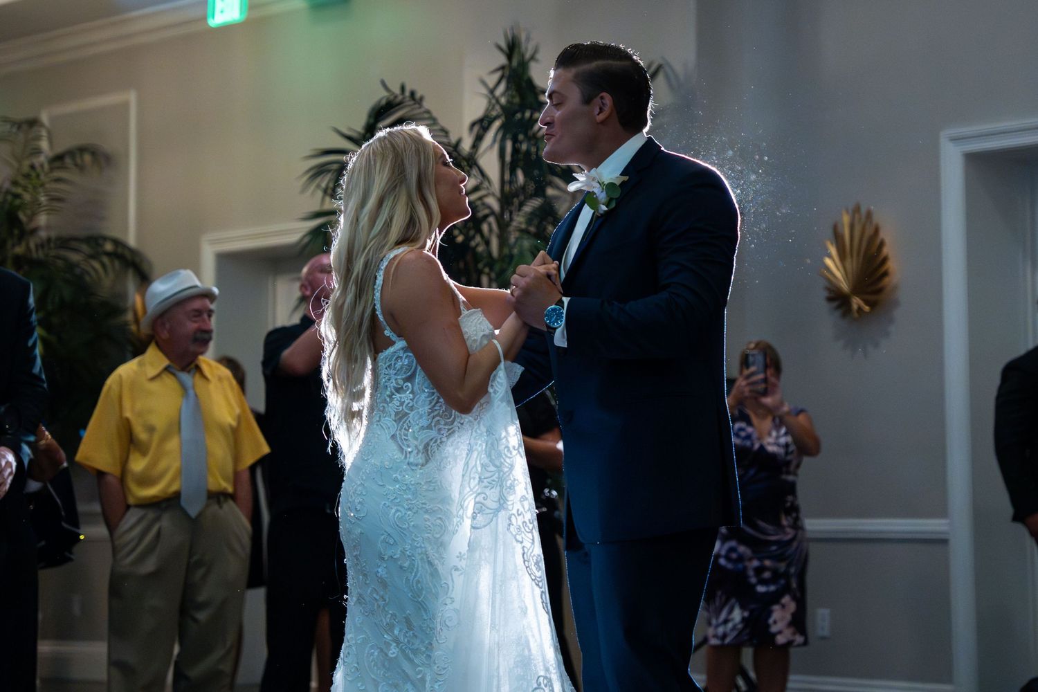 Bride and groom share a romantic kiss on the dance floor at their wedding reception.