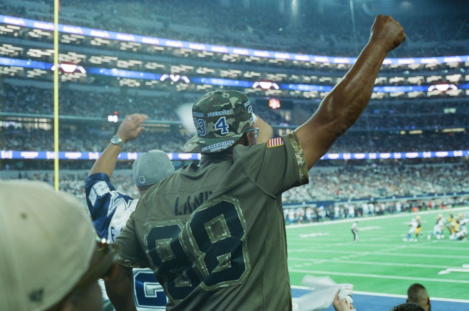 Dallas Cowboys fan in jersey number 88 celebrating with raised fists at NFL stadium game.