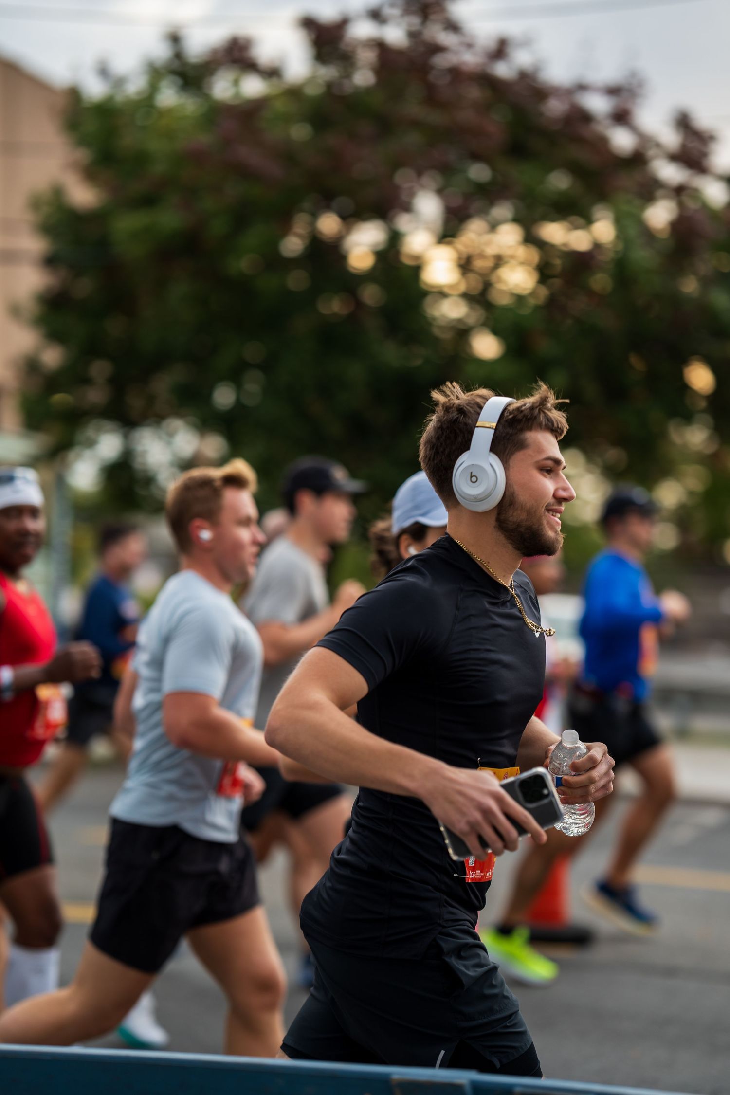 Male runner wearing white headphones during an outdoor road race.