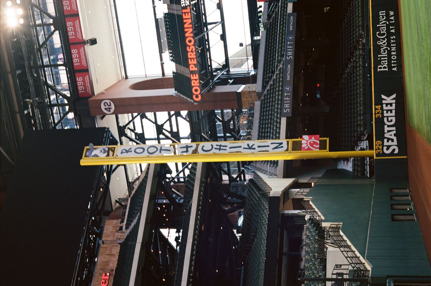 Interior view of a baseball stadium with yellow caution barriers and SeatGeek signage visible.