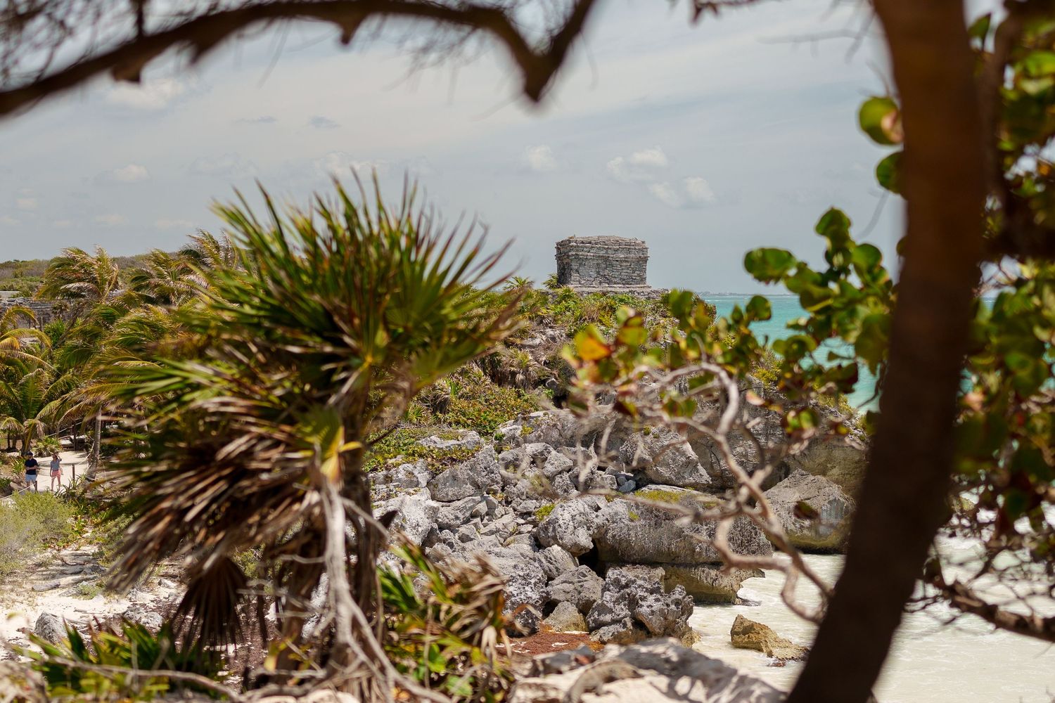 Ancient Mayan ruins perched on rocky cliffs overlooking turquoise Caribbean waters in Tulum.