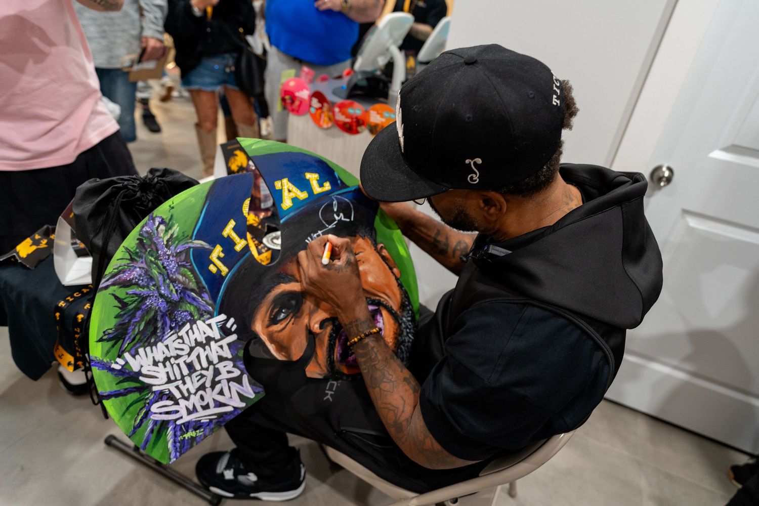 Person signing a colorful graffiti-style jacket at an indoor event.