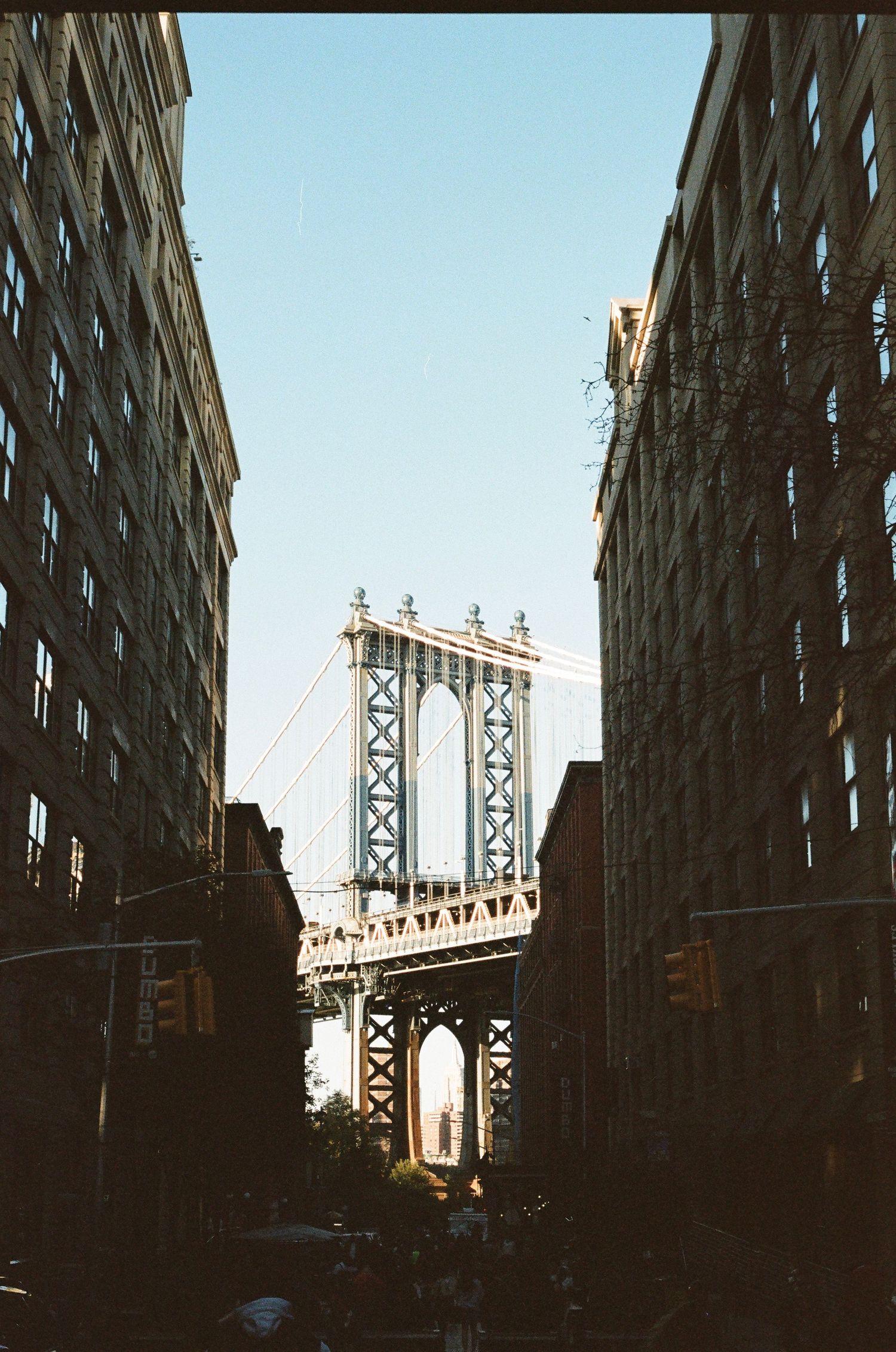 Manhattan Bridge framed between two brick buildings in the DUMBO neighborhood of Brooklyn, NYC.