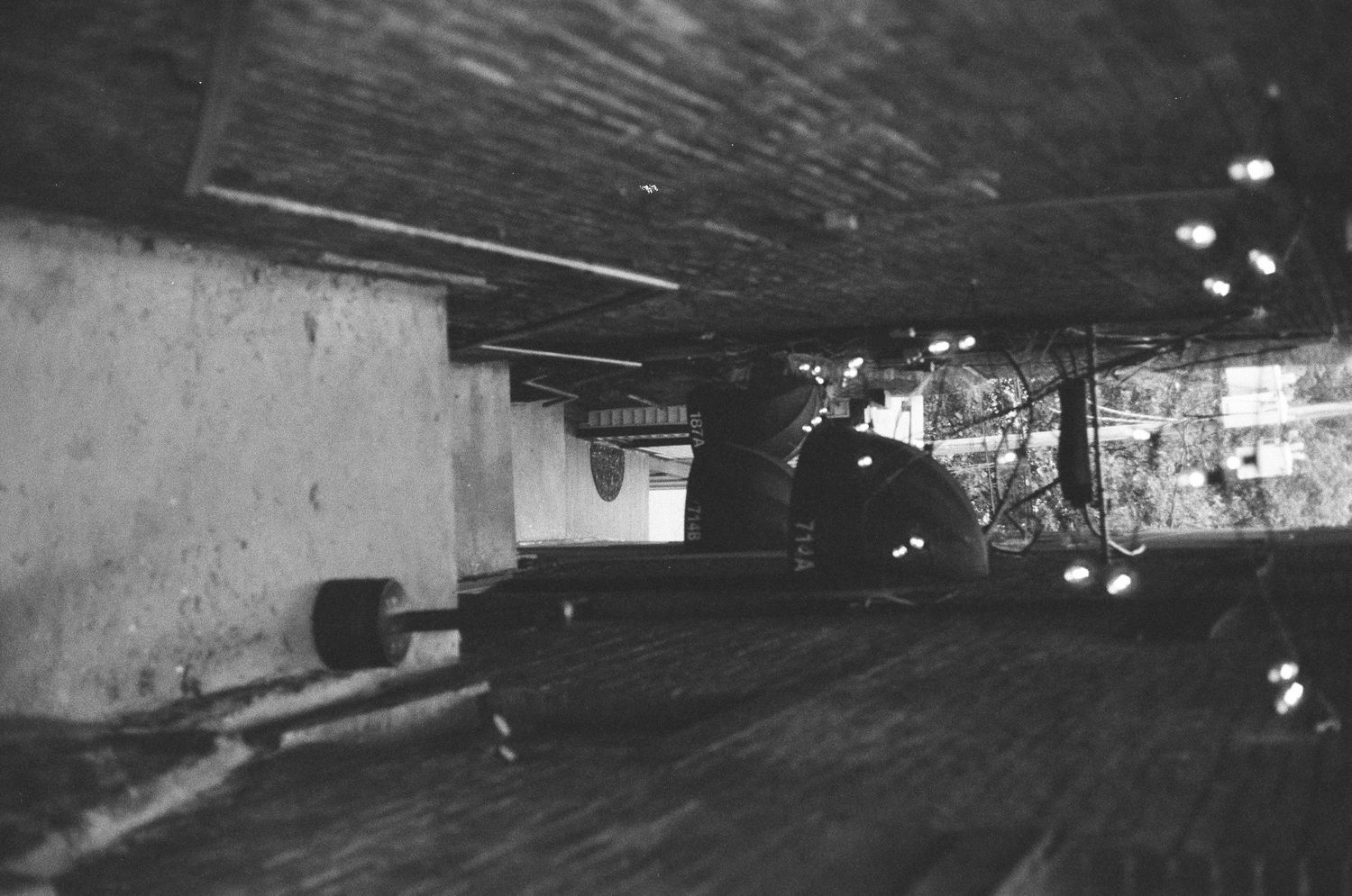 Dark black and white photo of underground parking garage with distant lights visible.