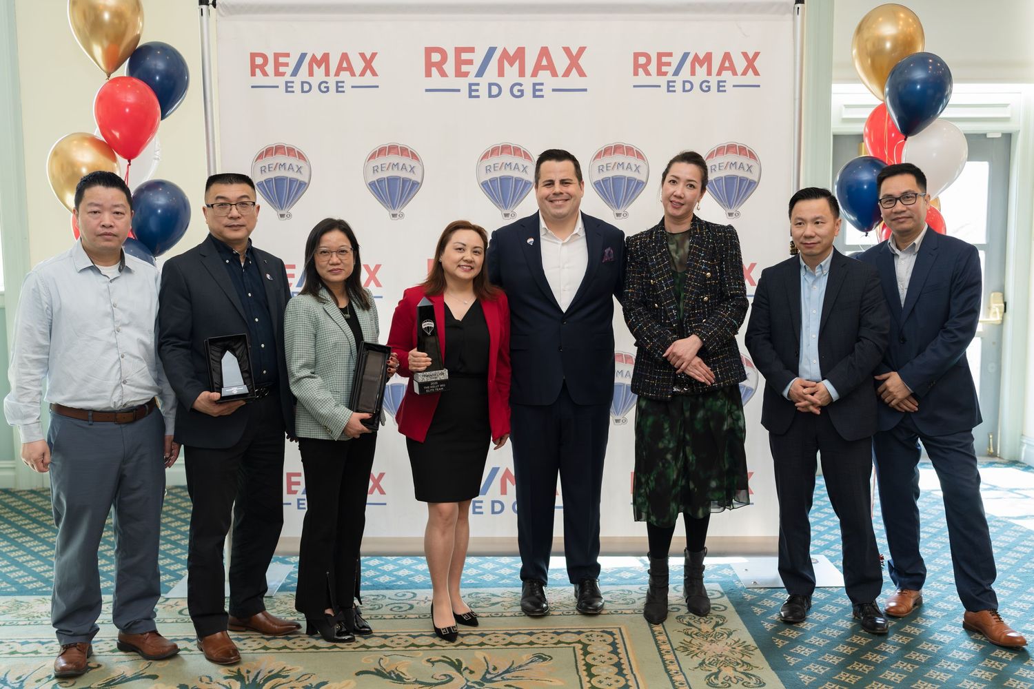 Group of nine RE/MAX Edge real estate professionals pose together at awards recognition event.