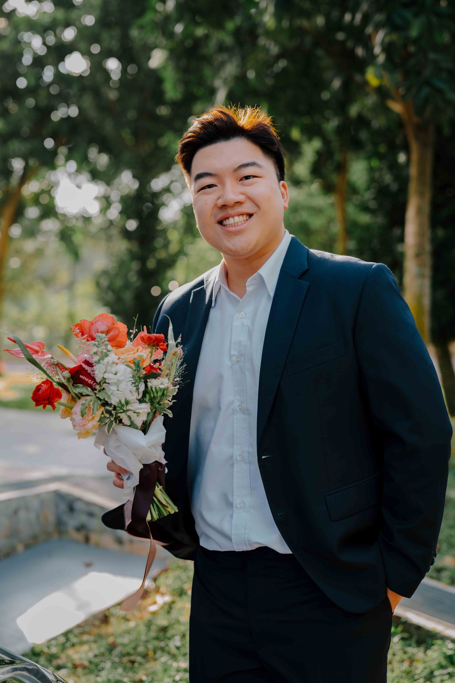 groom holding a floral wedding bouquet
