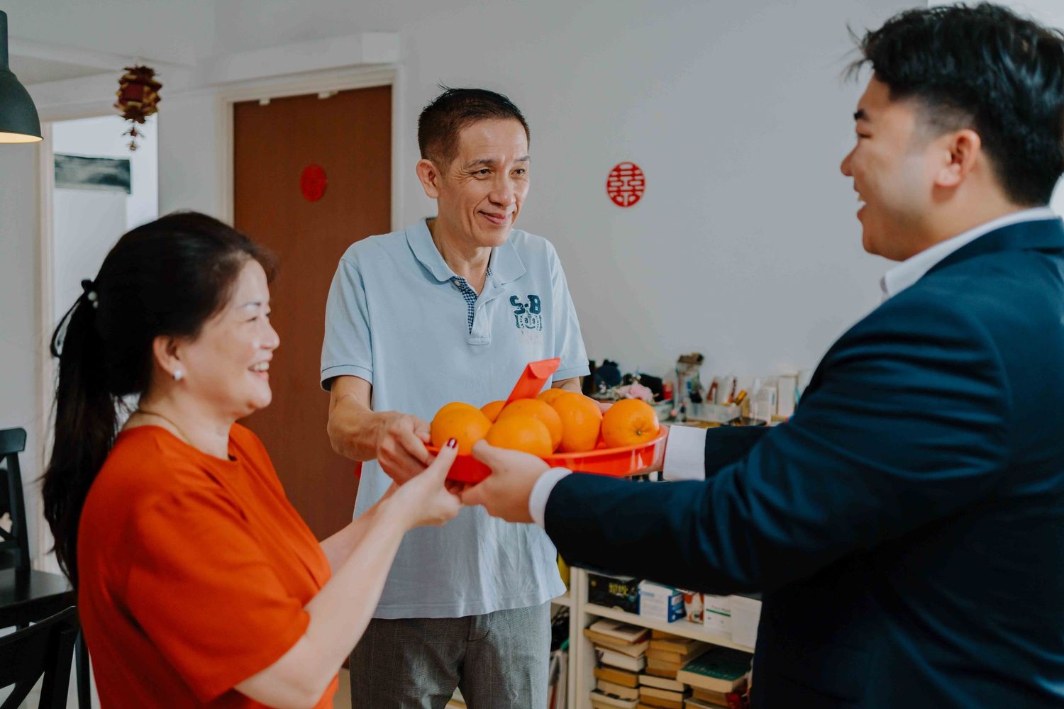 groom passing over a tray of oranges to bride's parents on wedding day