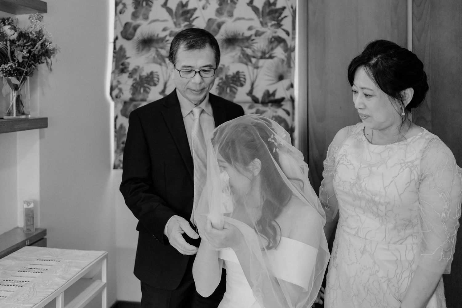emotional moment between bride and parents on wedding day photographed by documentary-style wedding photographer