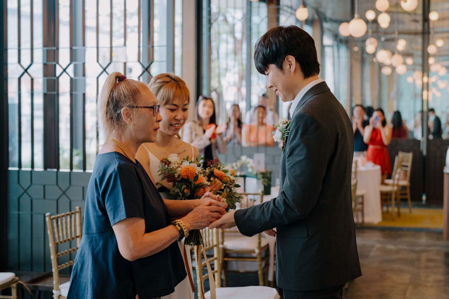 bride's mom hands over bride to groom