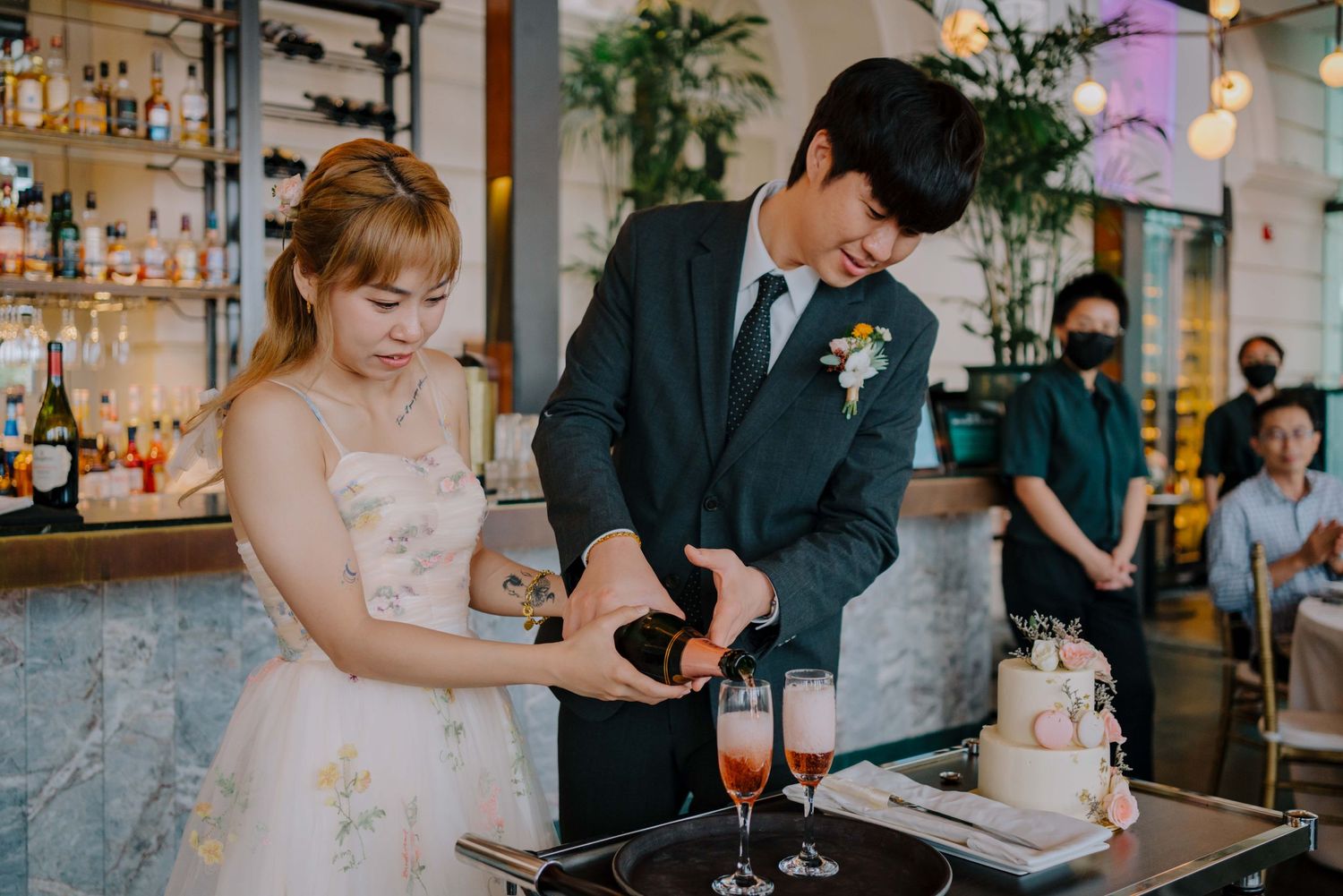 bride and groom pour champagne as newlywed